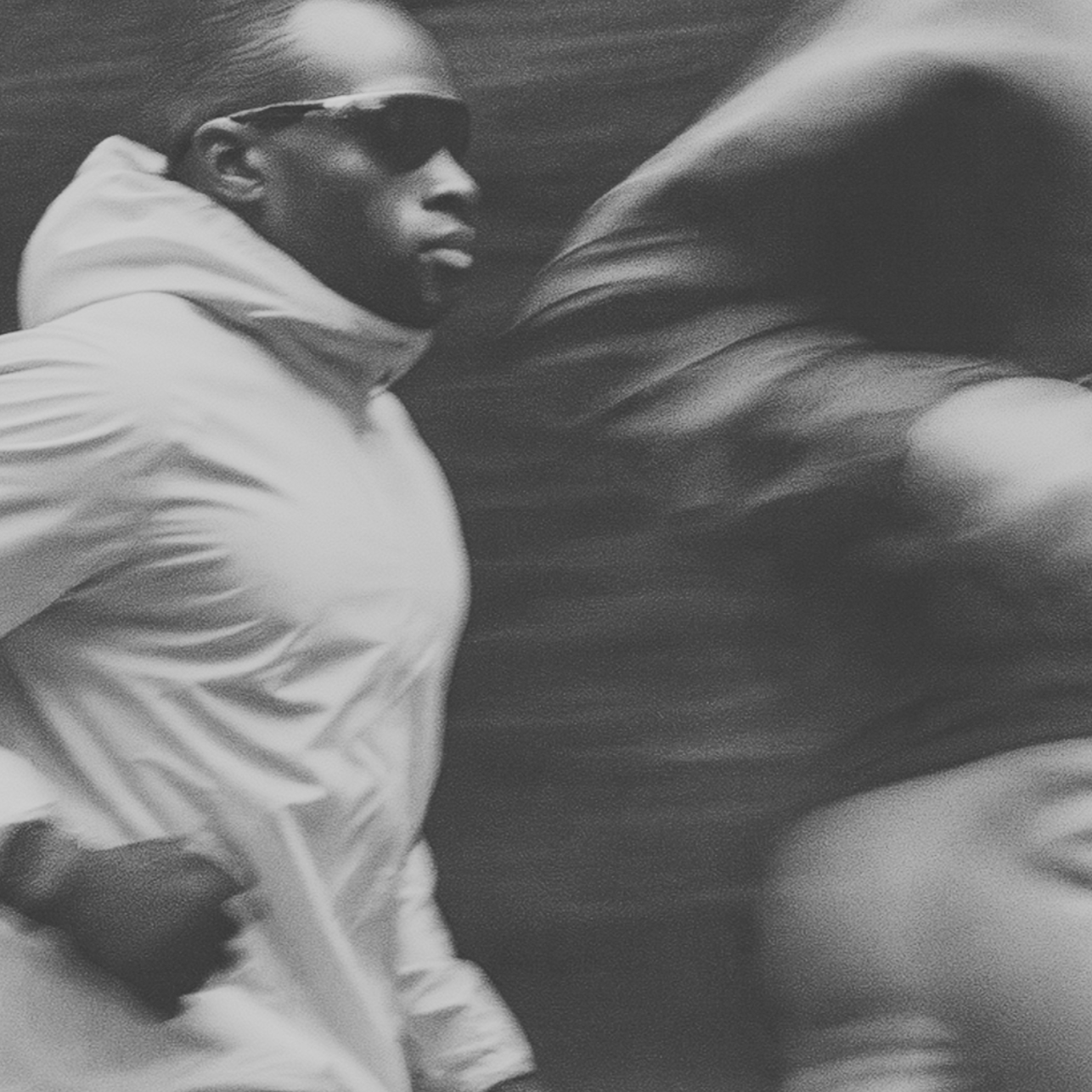 Person wearing a light-colored outfit and sunglasses in a black and white photo.
